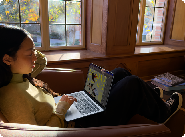 Inimene istumas toolil kasutamas oma MacBook Airi