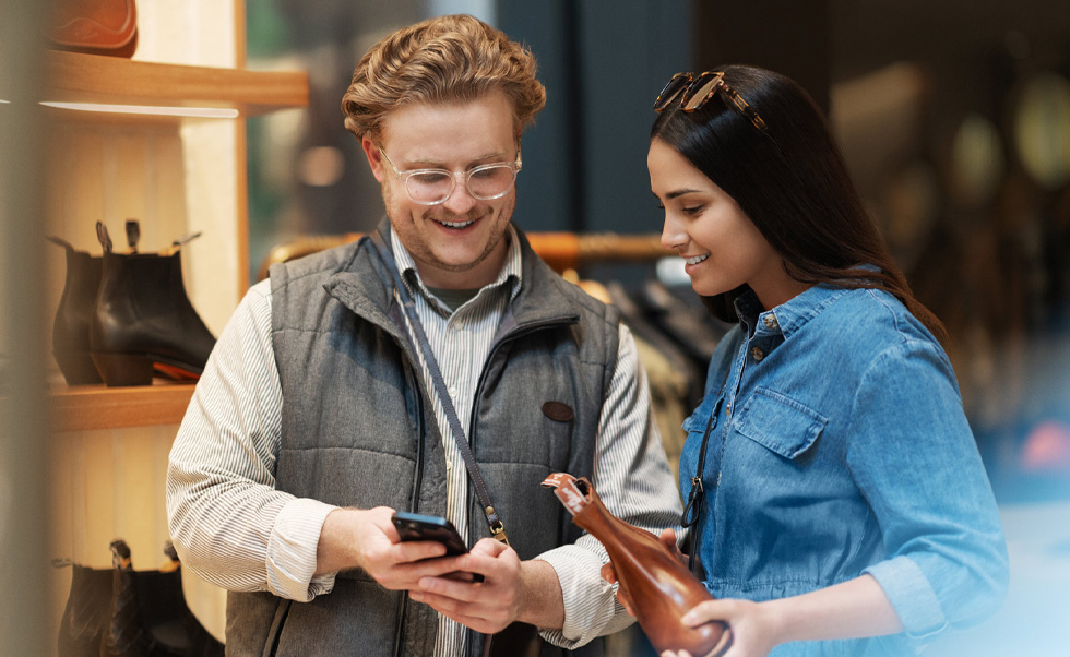 Un membre du personnel de vente utilise un iPhone pour aider une cliente en magasin.