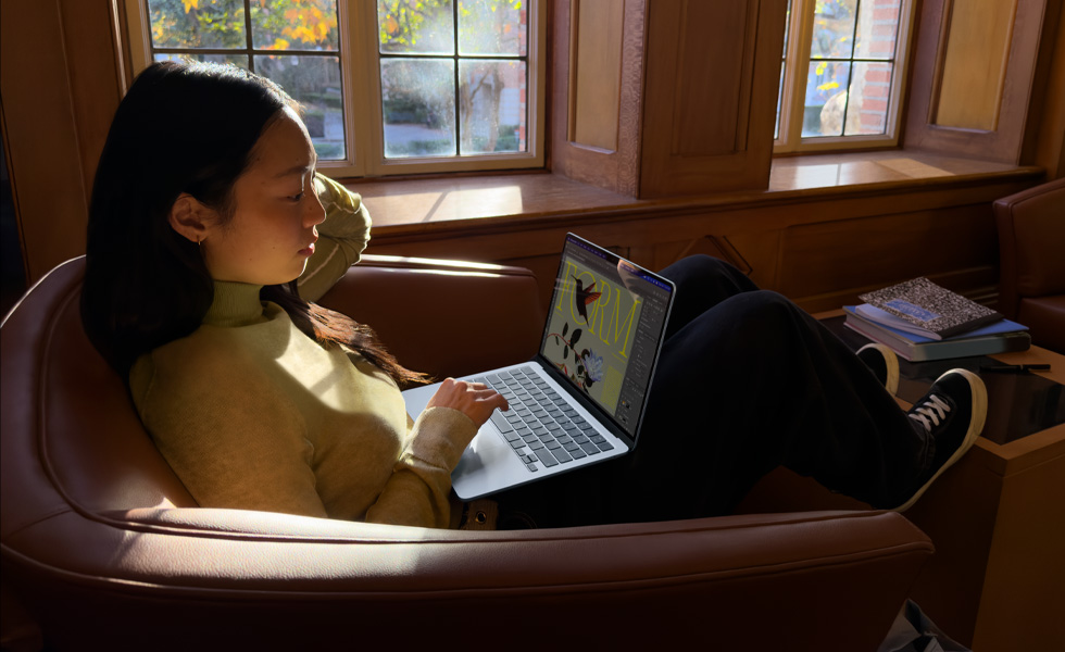 En person sidder på en stol og bruger en MacBook Air